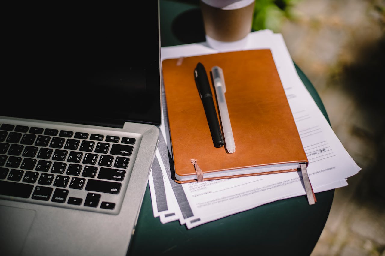 Planner and pens on table with laptop